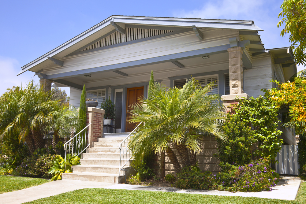 Bungalow-style home in San Diego with a palm plant in the front yard.